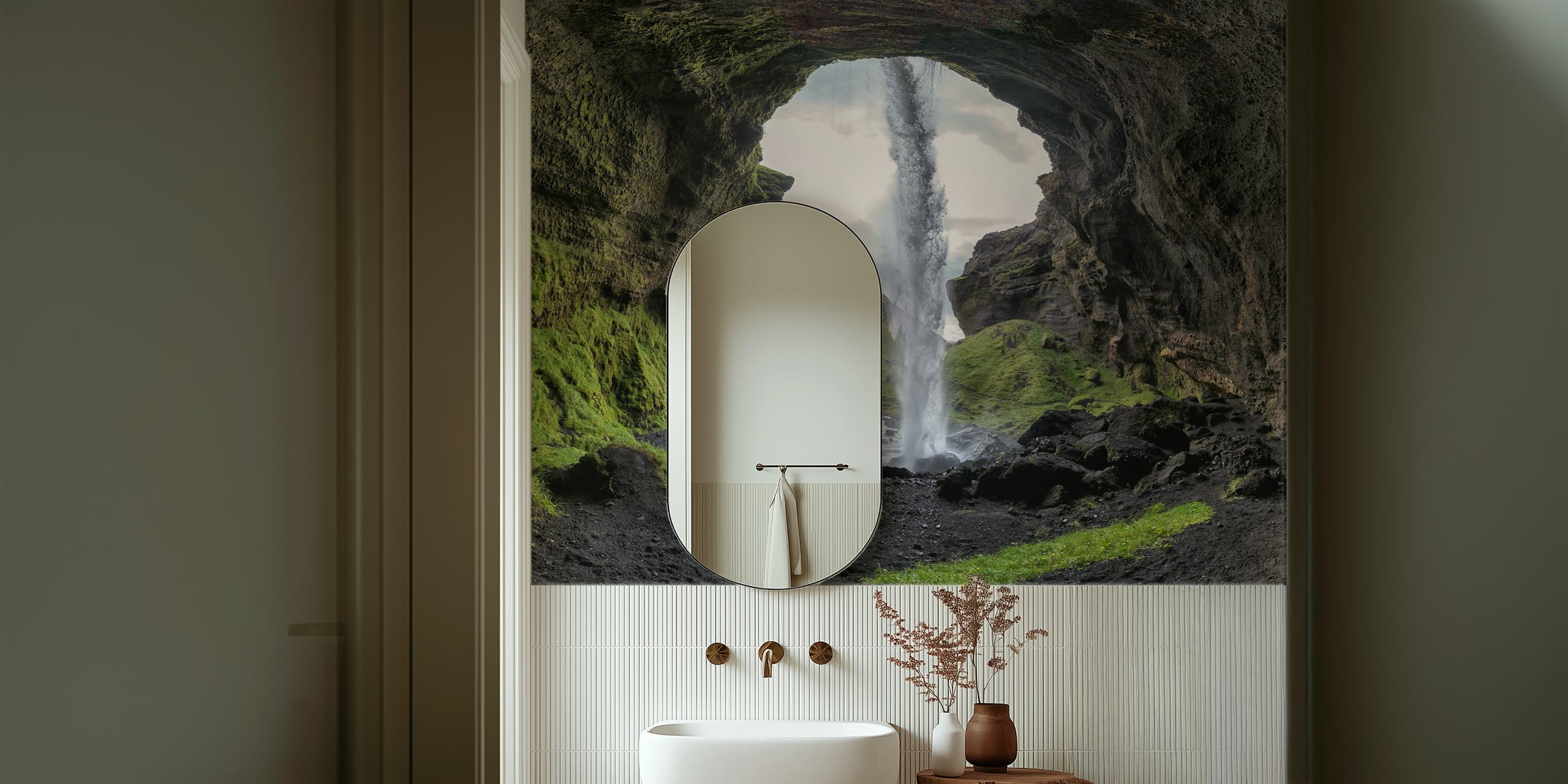 Cascading waterfall framed by rock formations and grass wallpaper