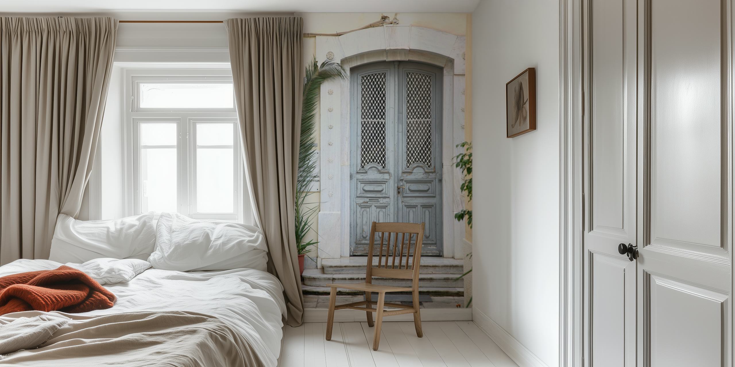 Et veggmaleri av en grå dør i gresk stil med en palmeplante til siden, som fremkaller en rolig middelhavsstemning.