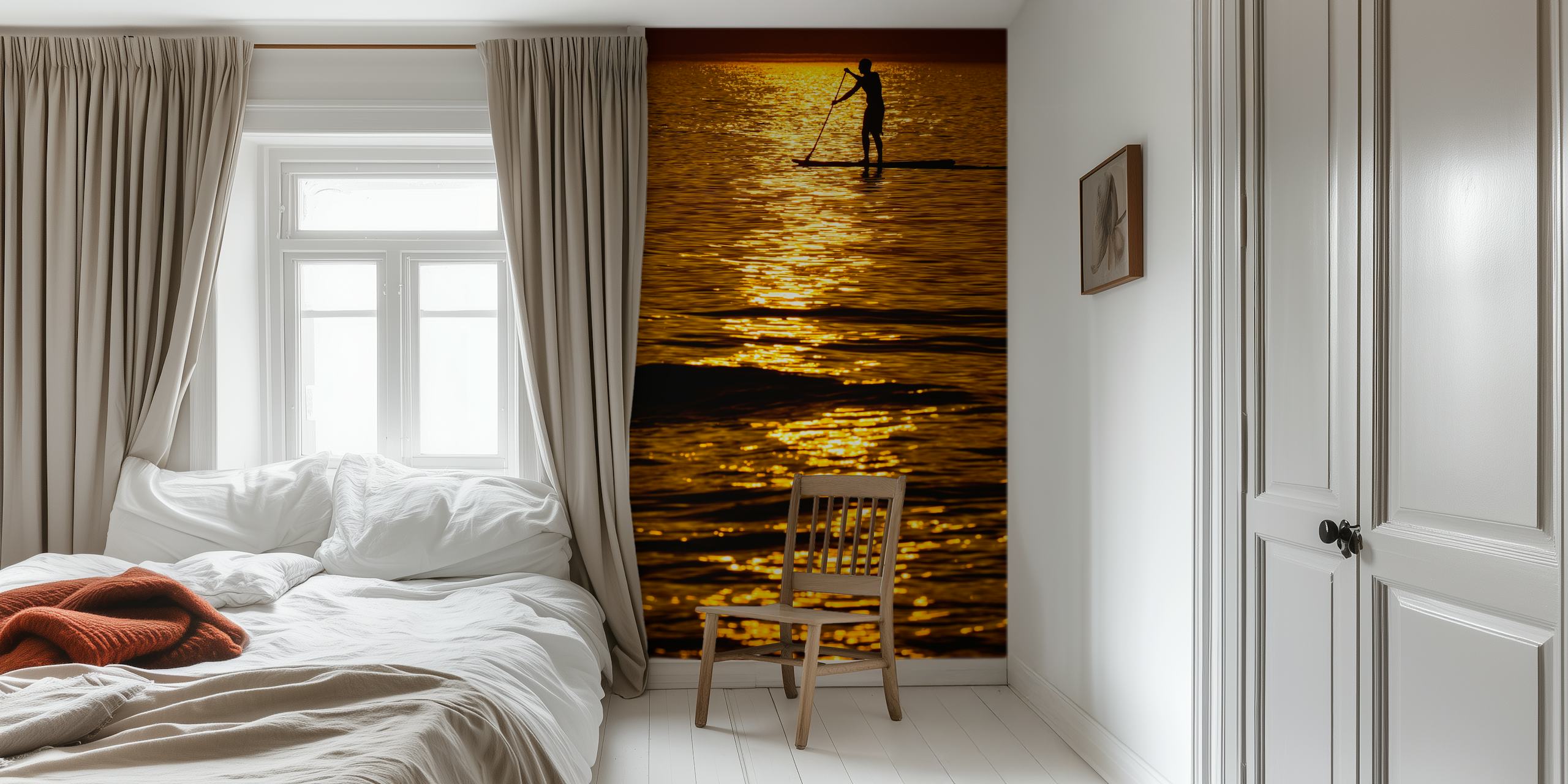 Silhouette of a person paddleboarding on a shimmering sea during a golden sunset