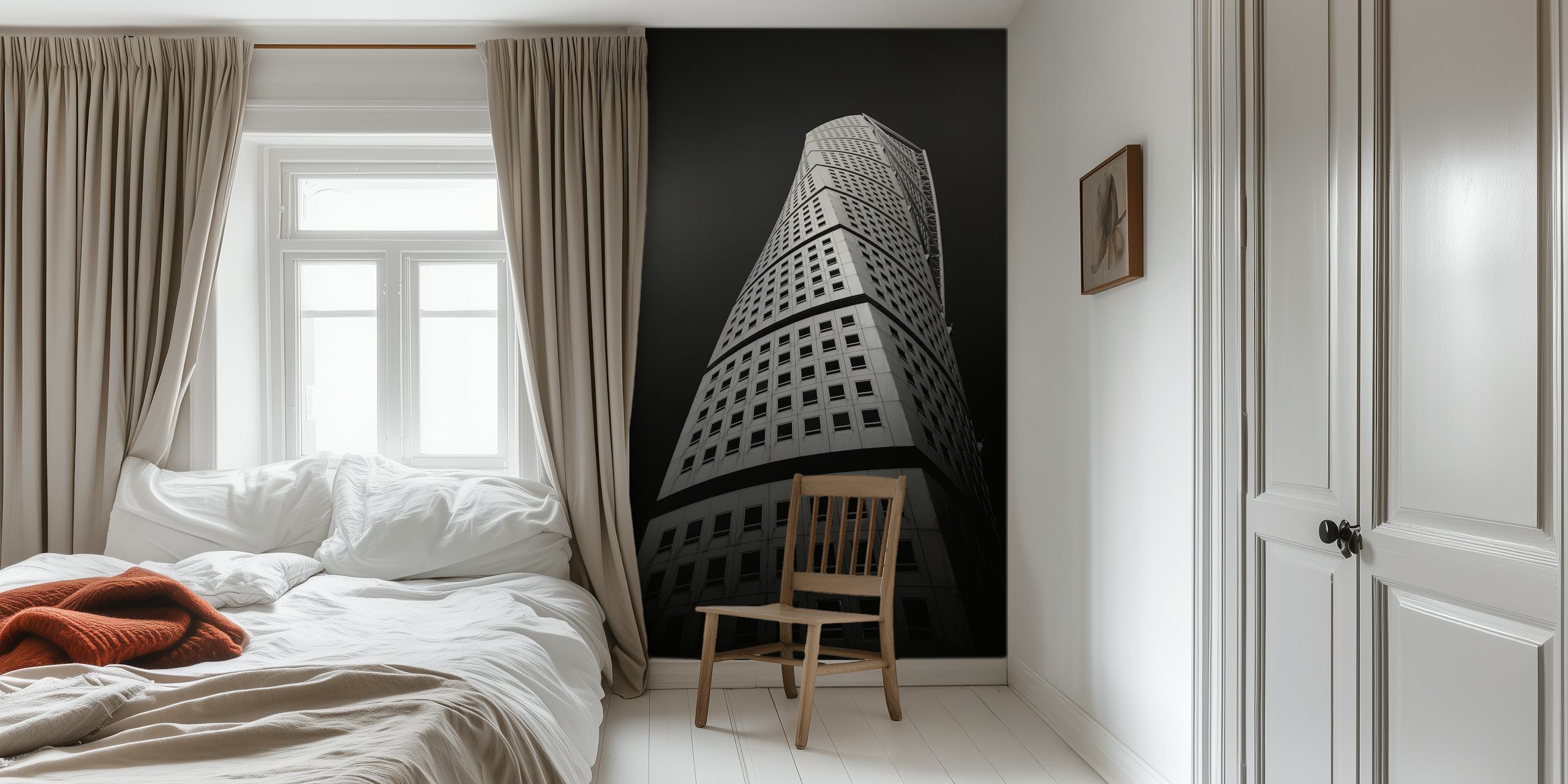 Monochrome wall mural of a twisting skyscraper against a dark sky