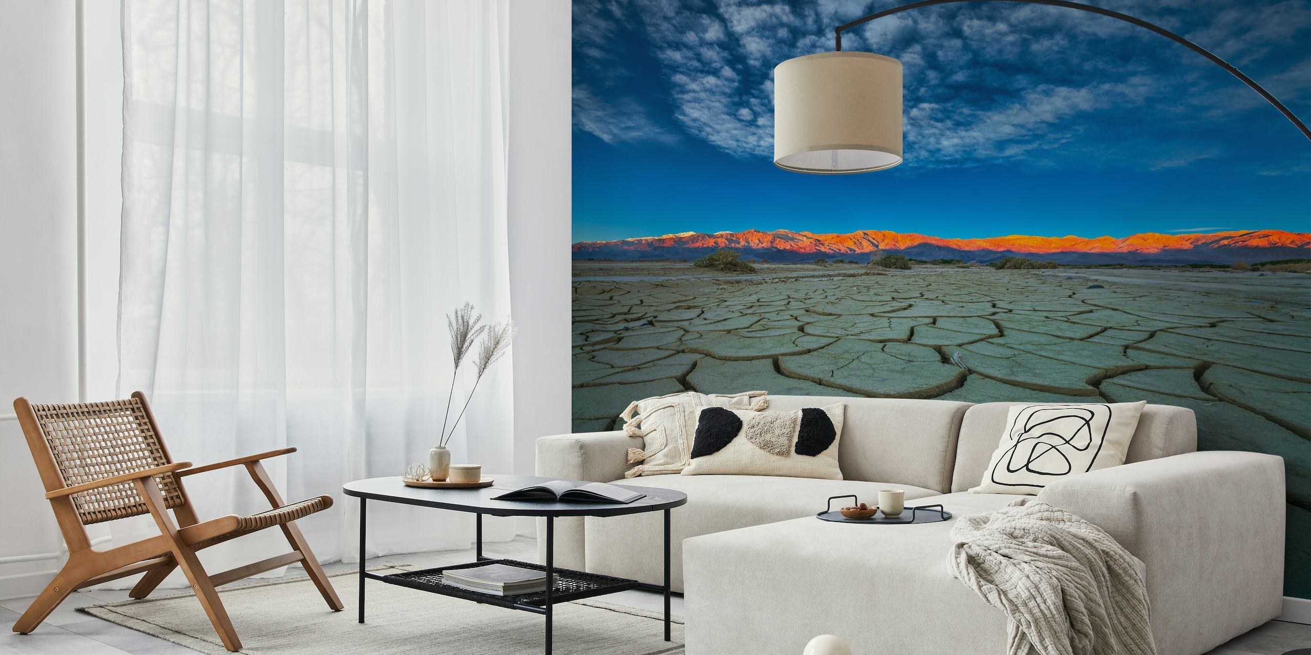 Cracked dry earth with distant sunset-lit mountains wall mural