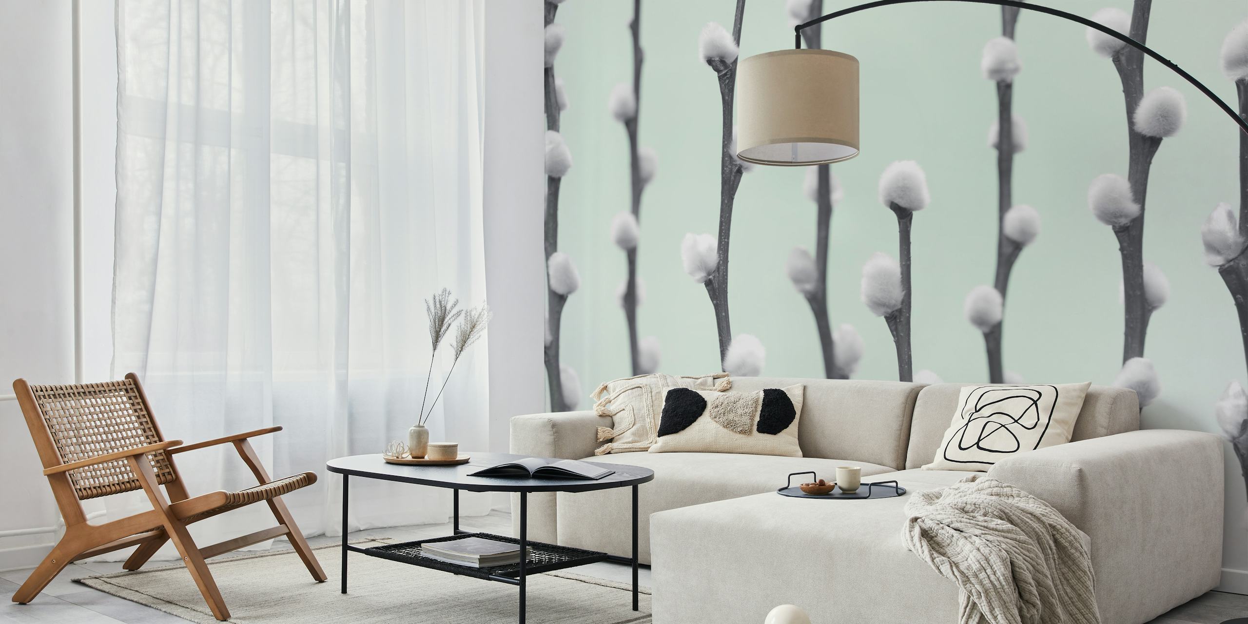 White pussy willow twigs with fluffy buds on light mint wallpaper