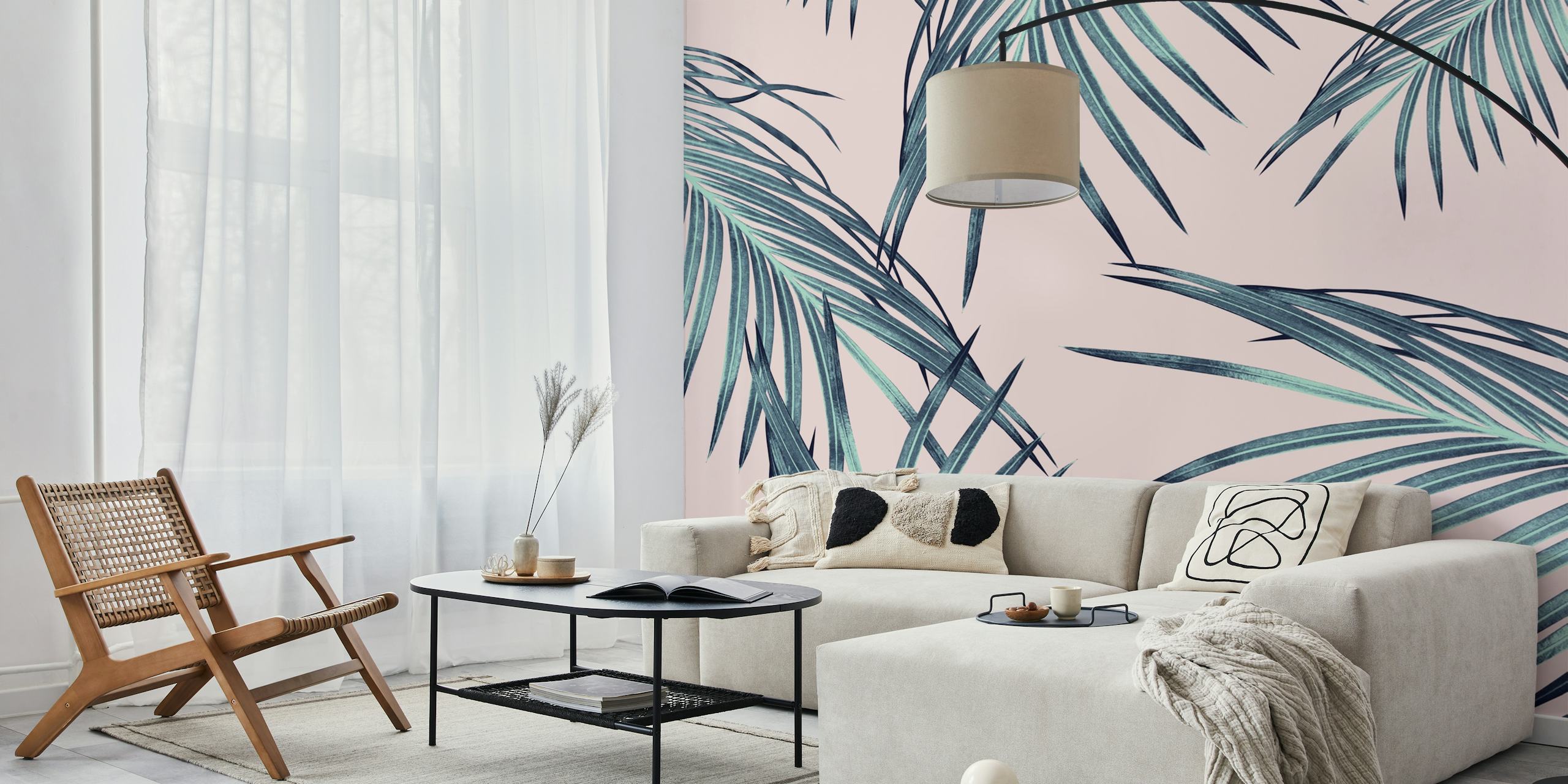 Tropical palm leaves in green and teal colors on pink wallpaper