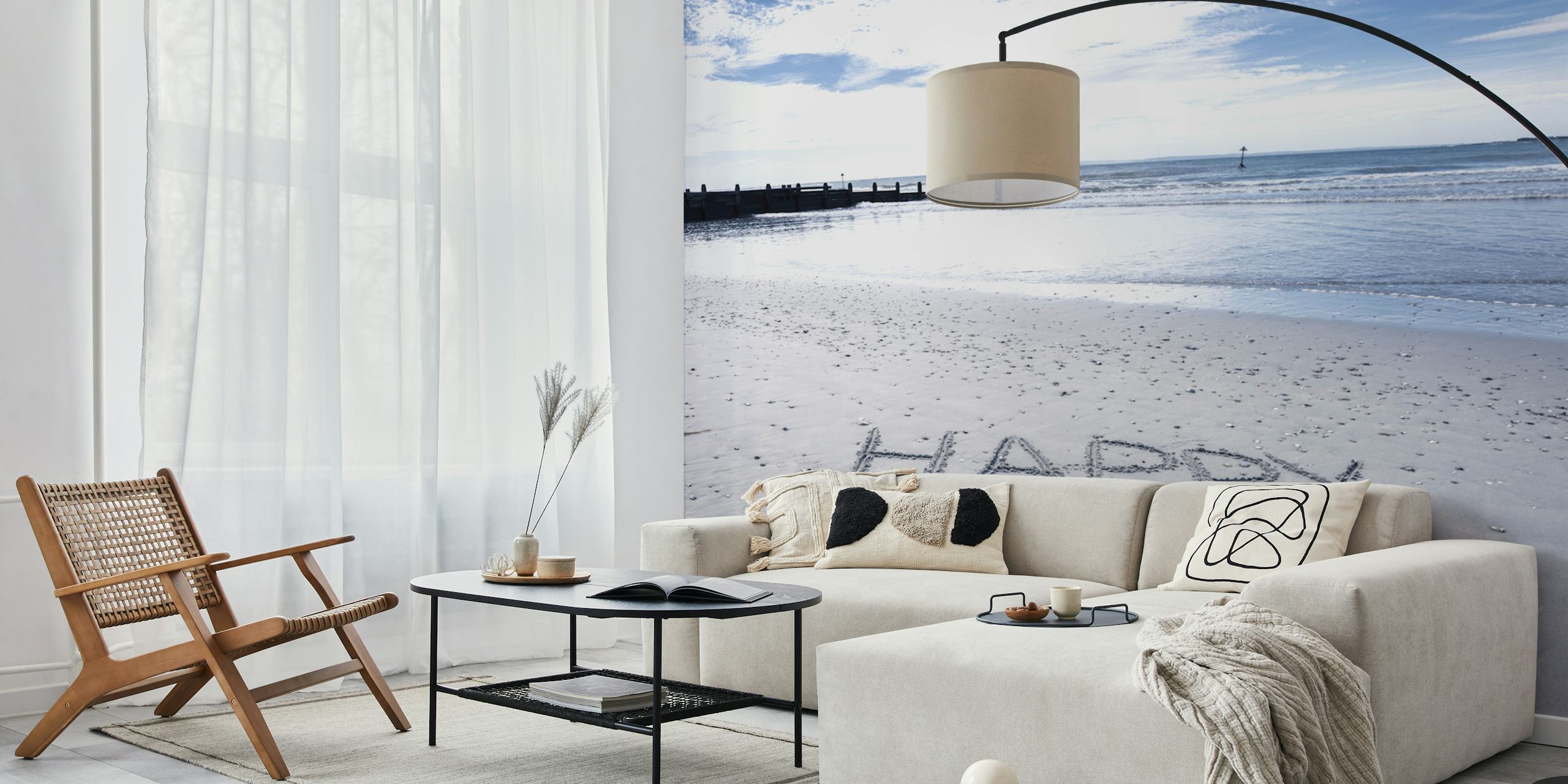 Coastal beach scene with 'HAPPY' written in sand, blue water wallpaper