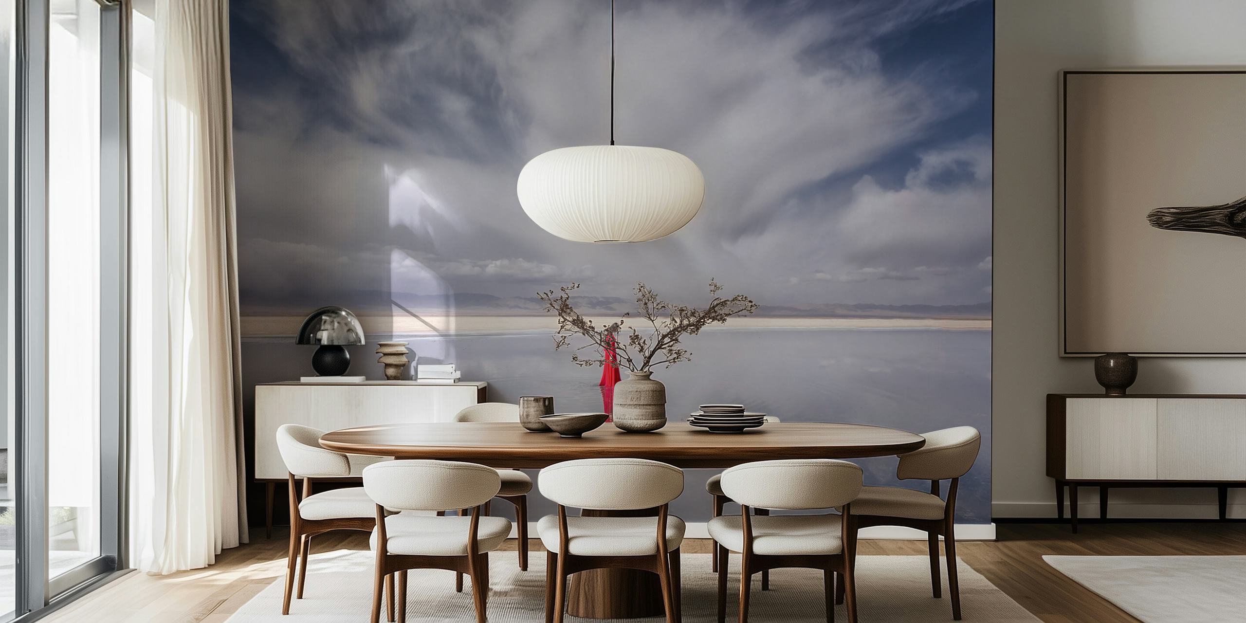 En ensam kvinna i röd klänning som står mot en fridfull bakgrund av himmel och vatten som blandas vid horisonten