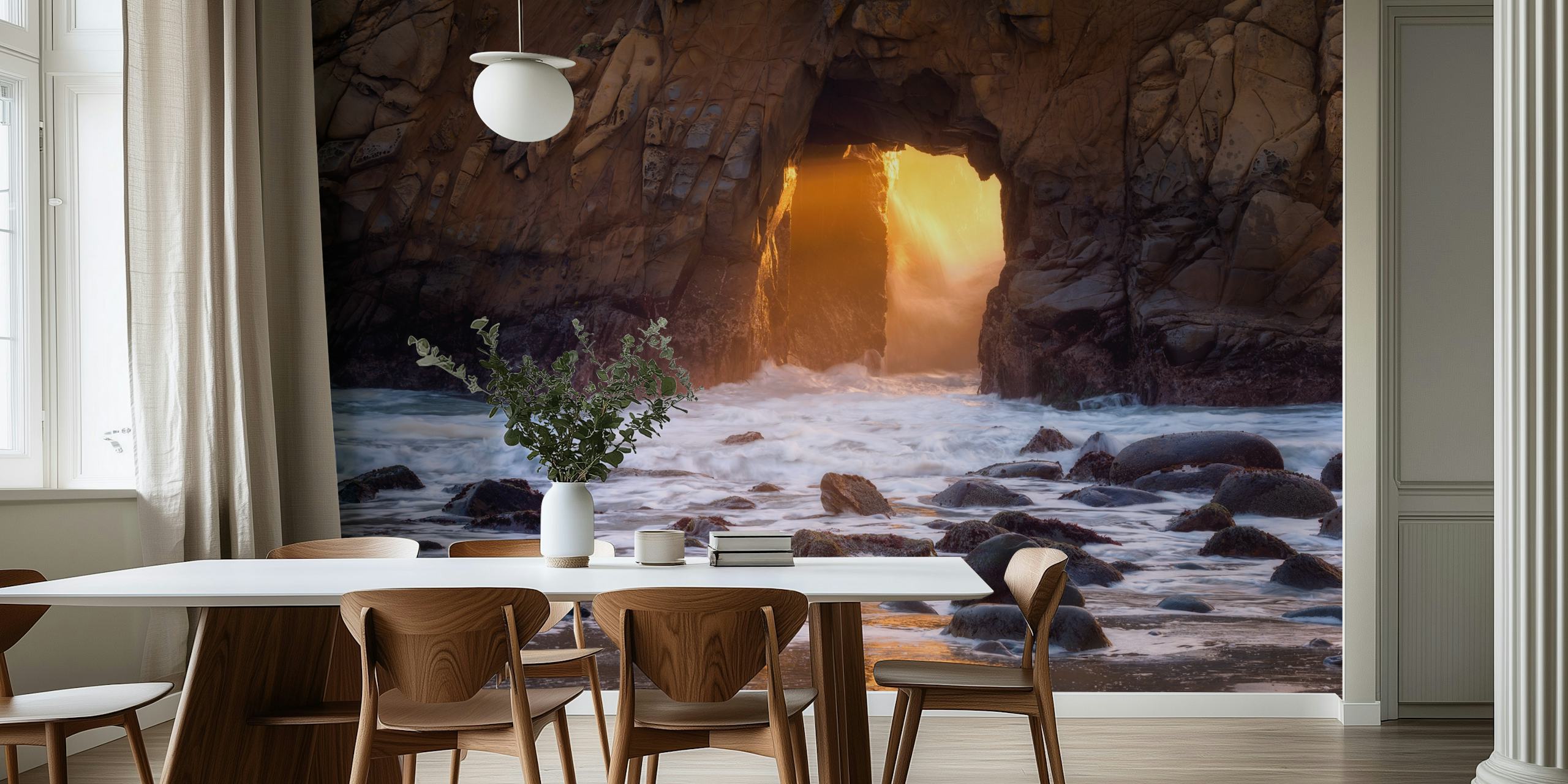 Mural de pared al atardecer con un arco de roca brillante sobre una playa