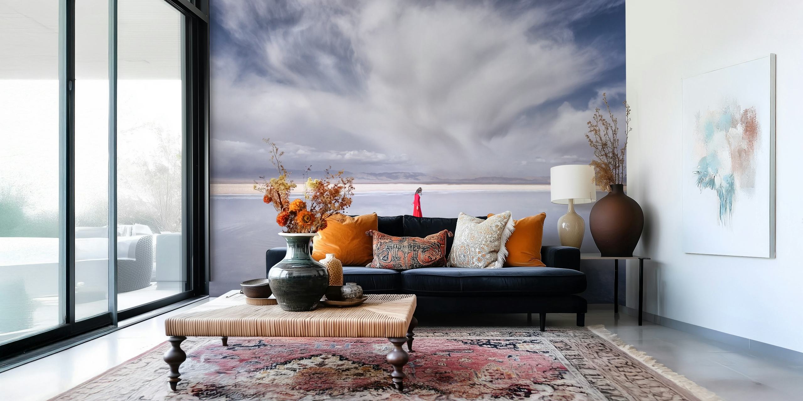 En ensam kvinna i röd klänning som står mot en fridfull bakgrund av himmel och vatten som blandas vid horisonten