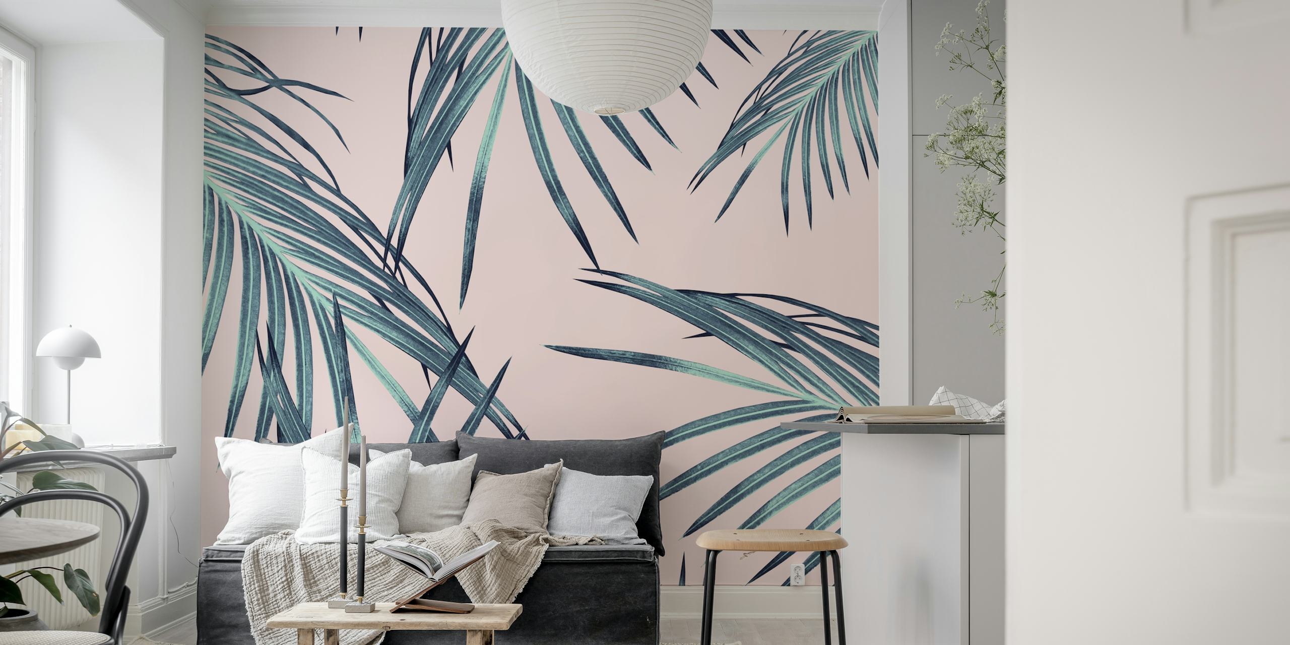Tropical palm leaves in green and teal colors on pink wallpaper