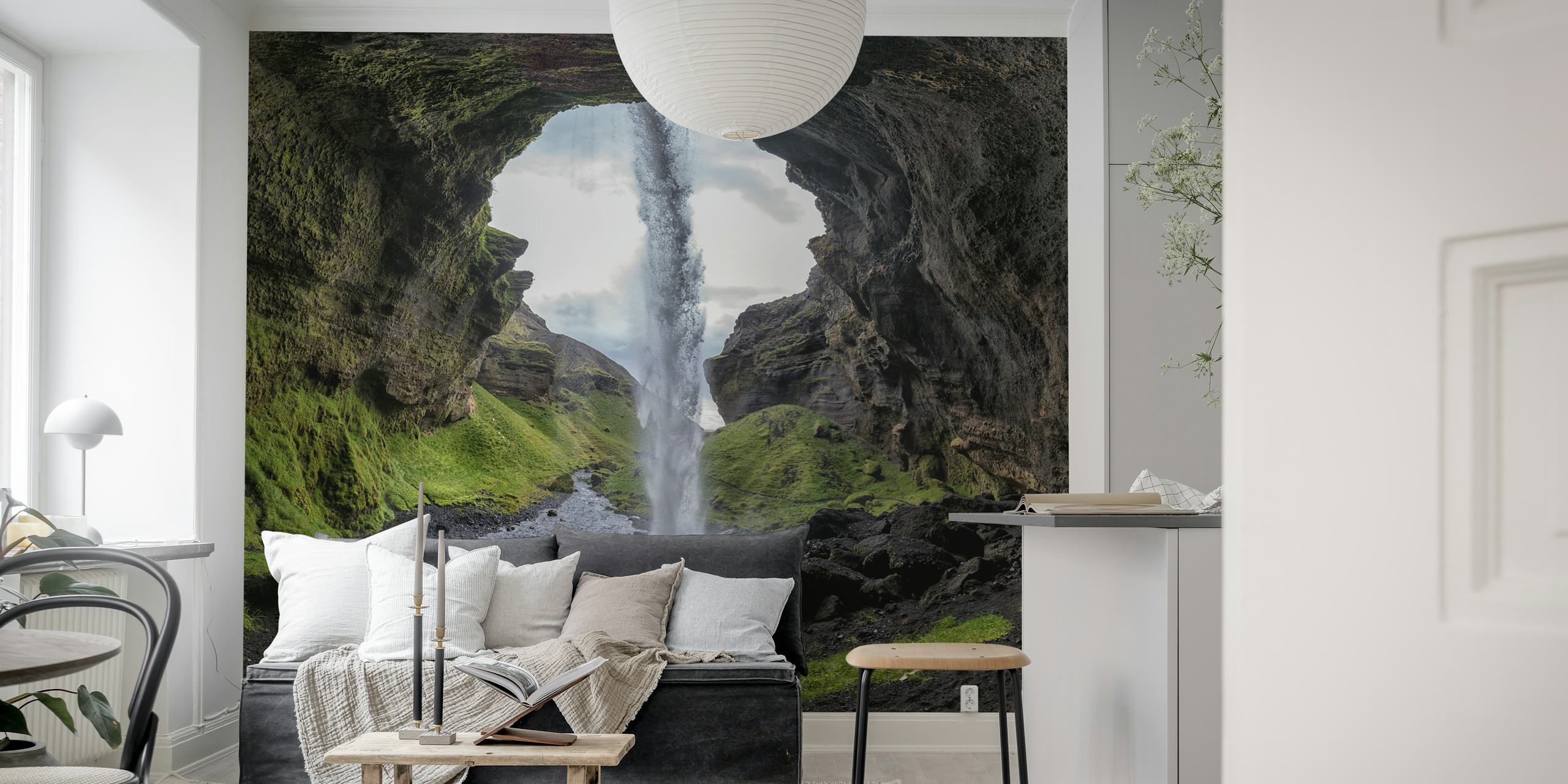 Cascading waterfall framed by rock formations and grass wallpaper
