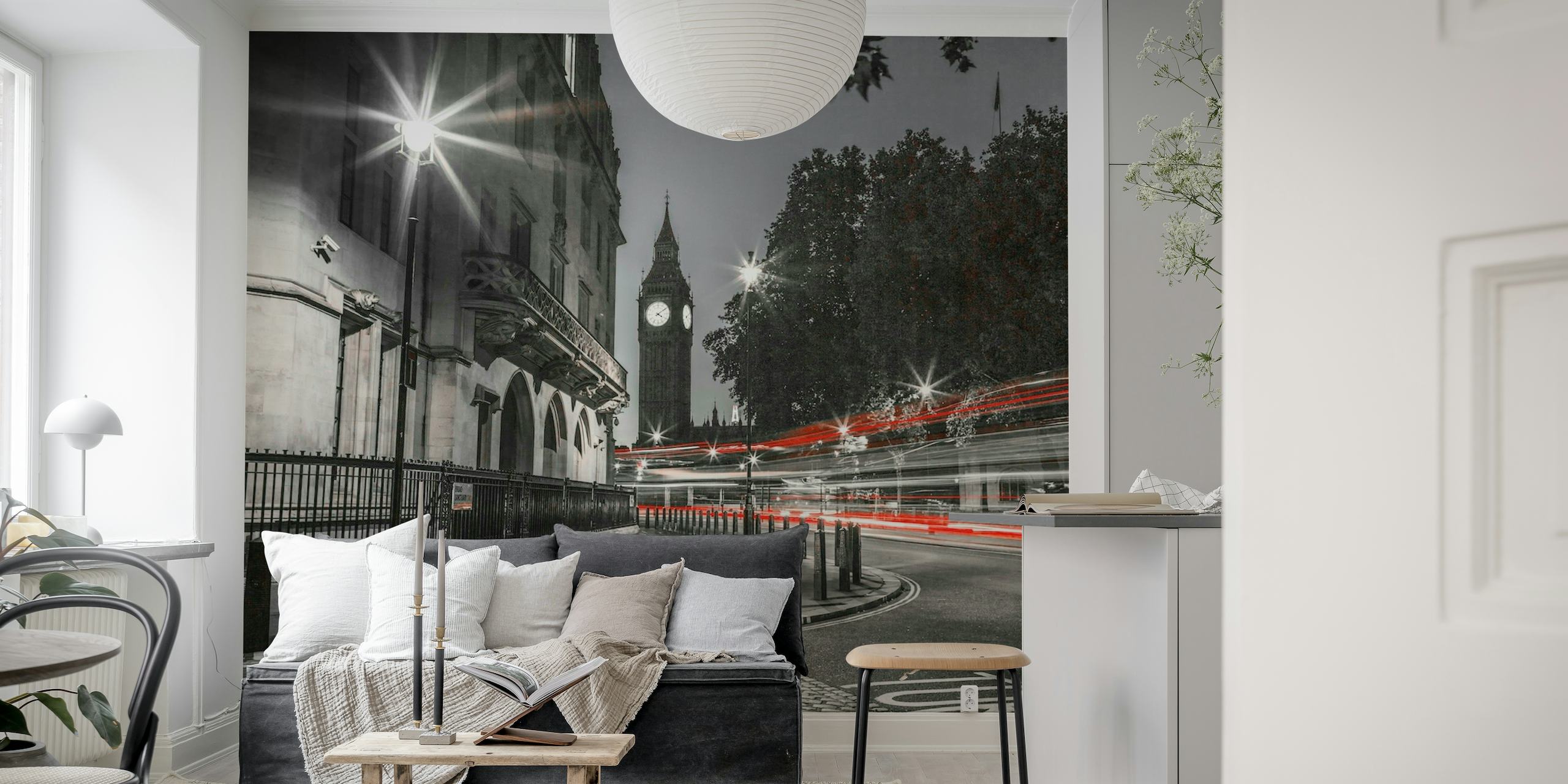 Black and white wall mural of Big Ben with red double-decker bus lights in motion at night in London.