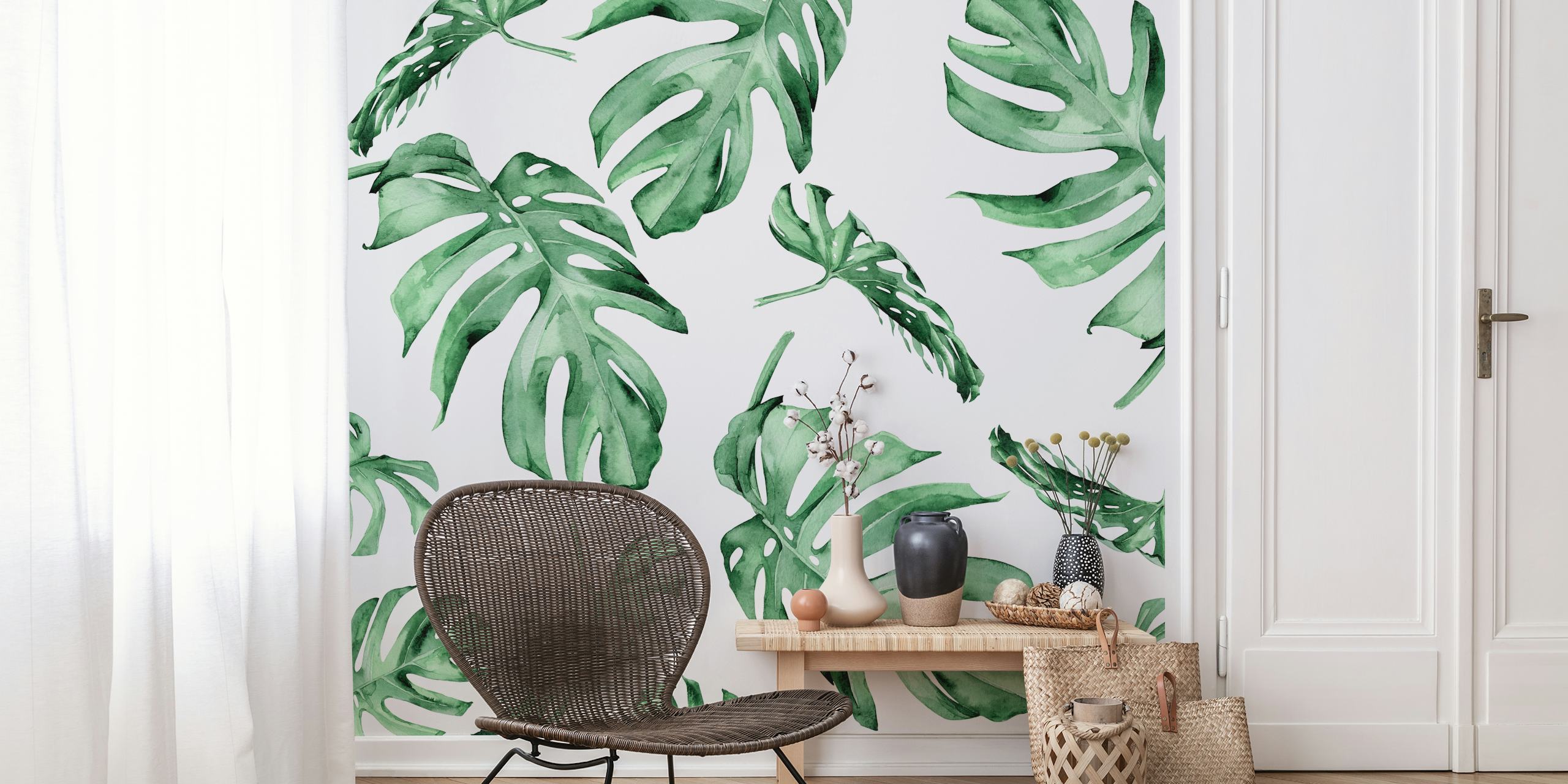 Monstera leaves in various shades of green on a white wallpaper