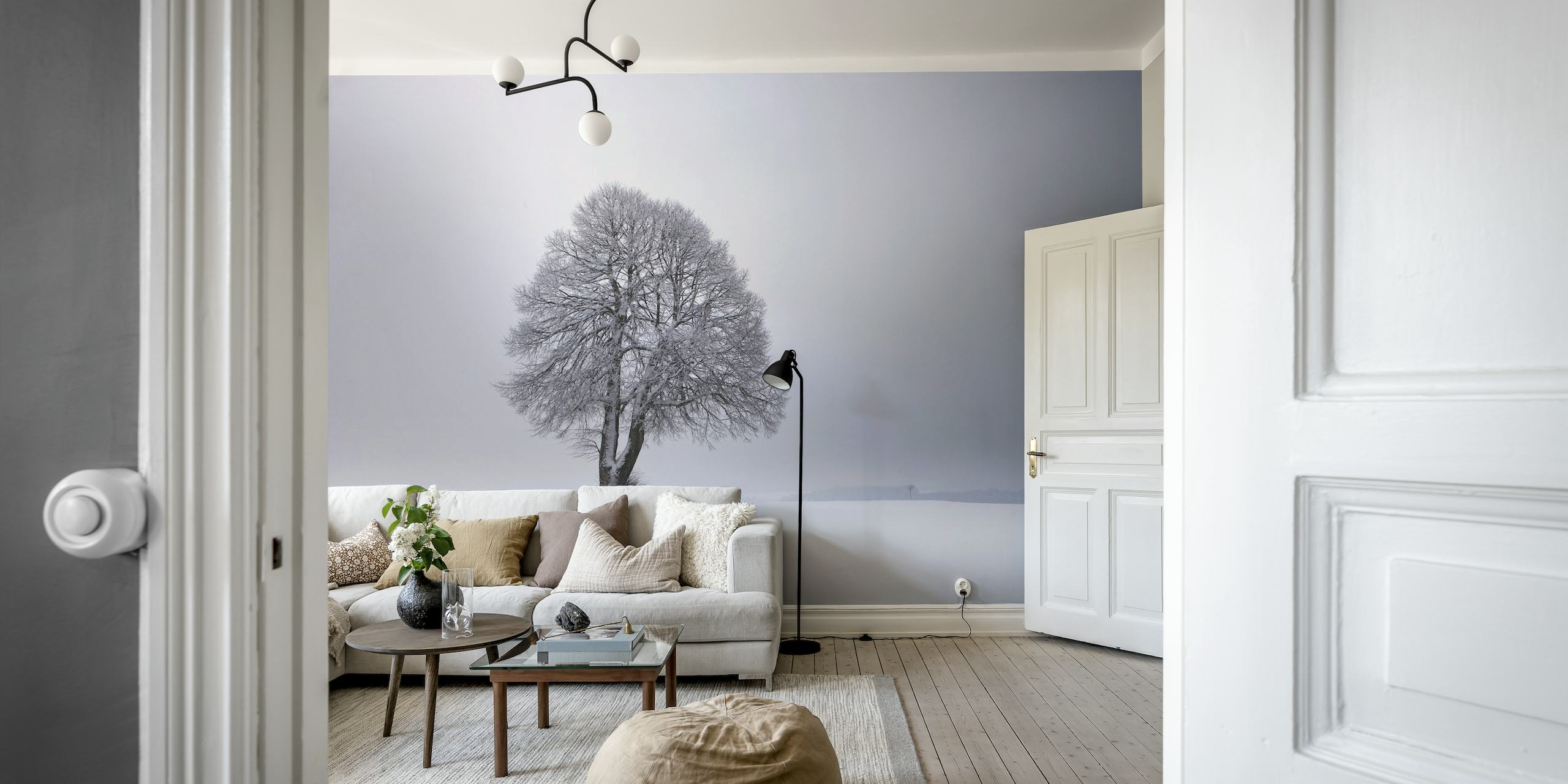 Solitary tree with frost-covered branches in a snowy landscape wall mural