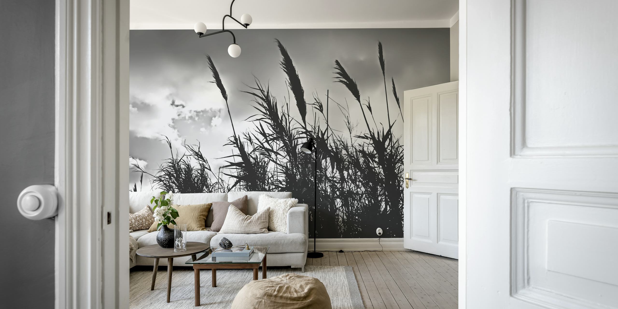 Black and white silhouette of tall wild grass against a cloudy sky wall mural