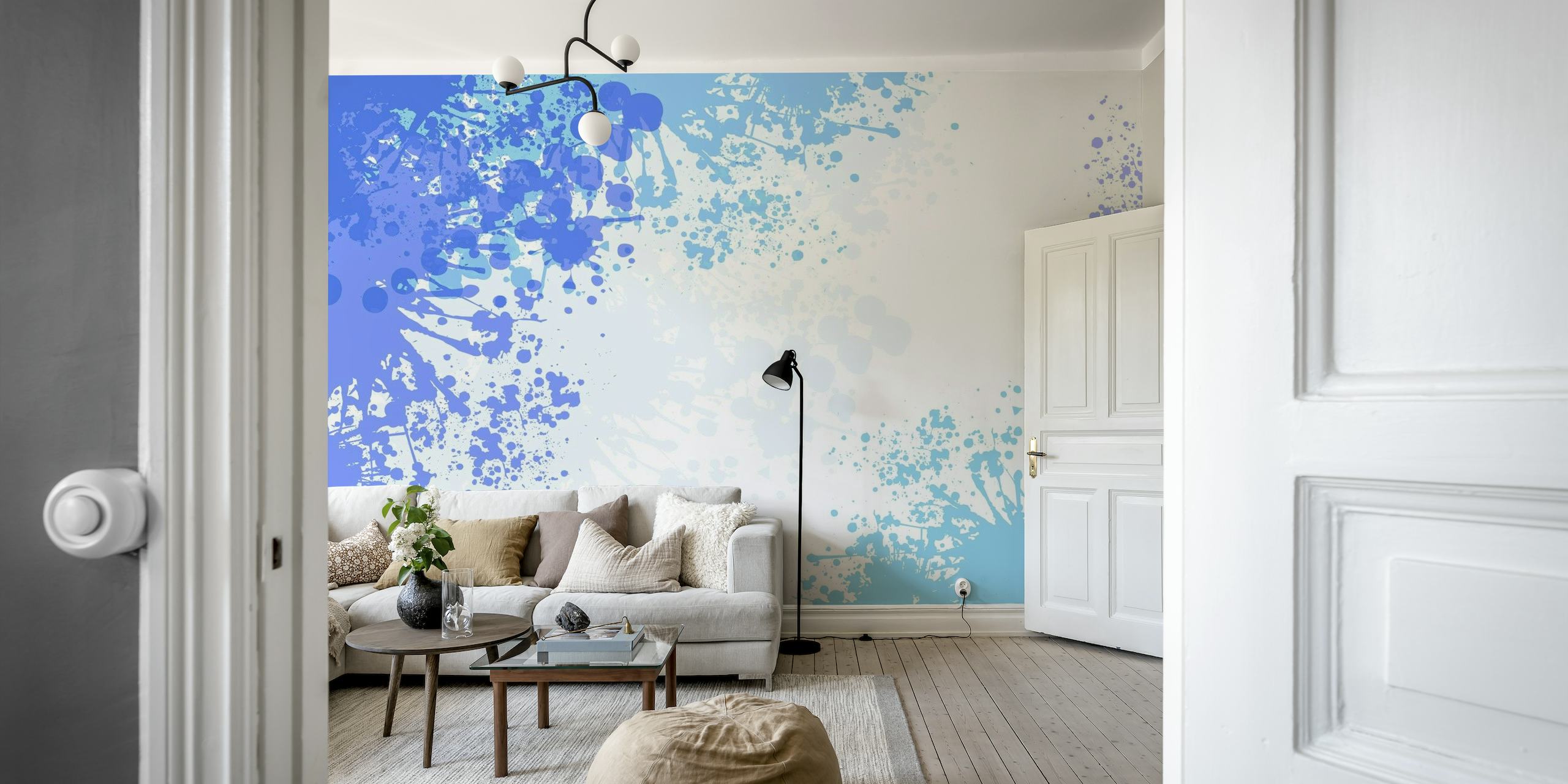 Abstrakt lyseblå splash art vægmaleri med en blanding af hvide og dybere blå drypper på en væg.