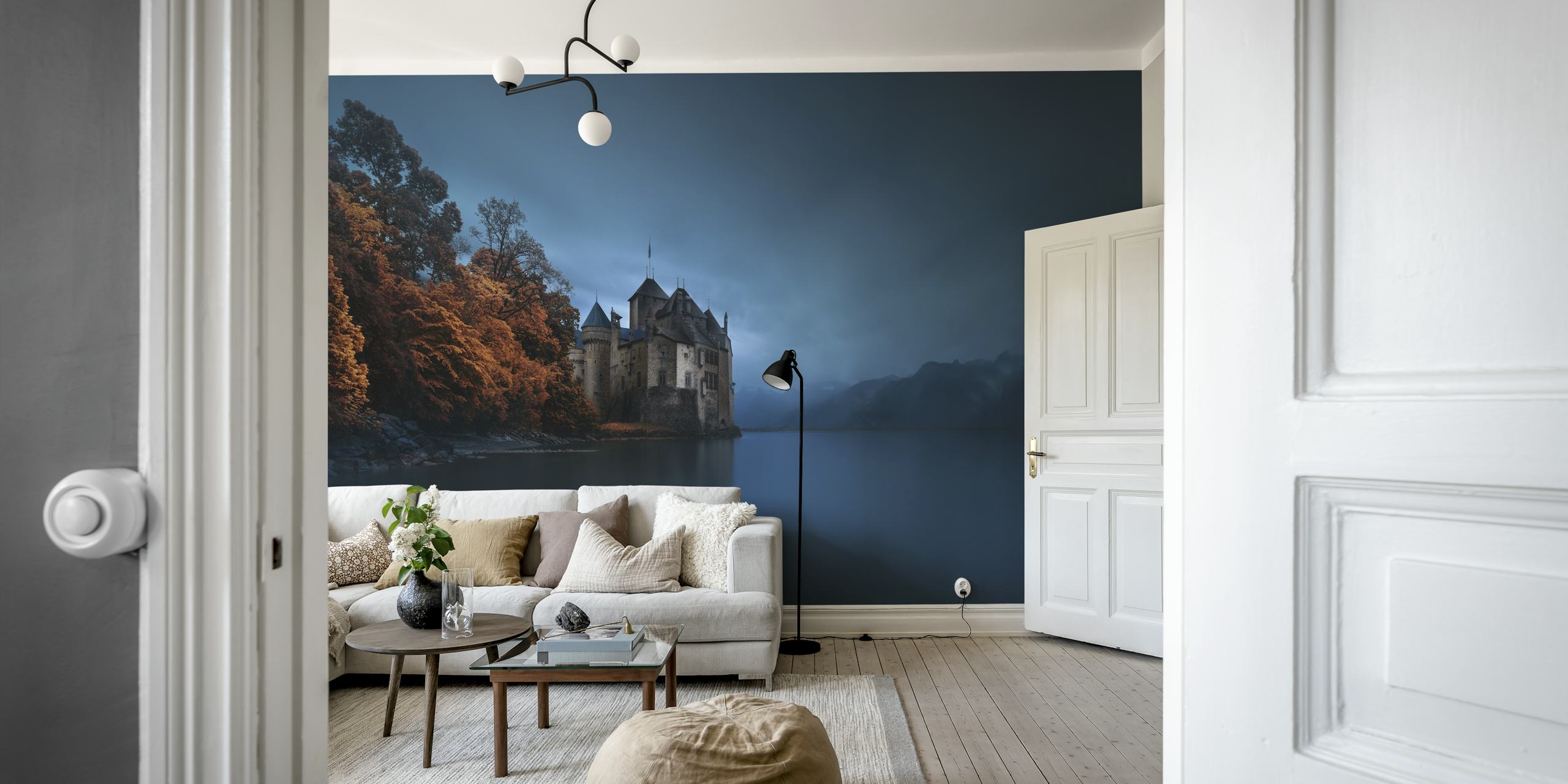 Dark castle on the edge of a serene lake surrounded by autumn foliage and mountains wallpaper