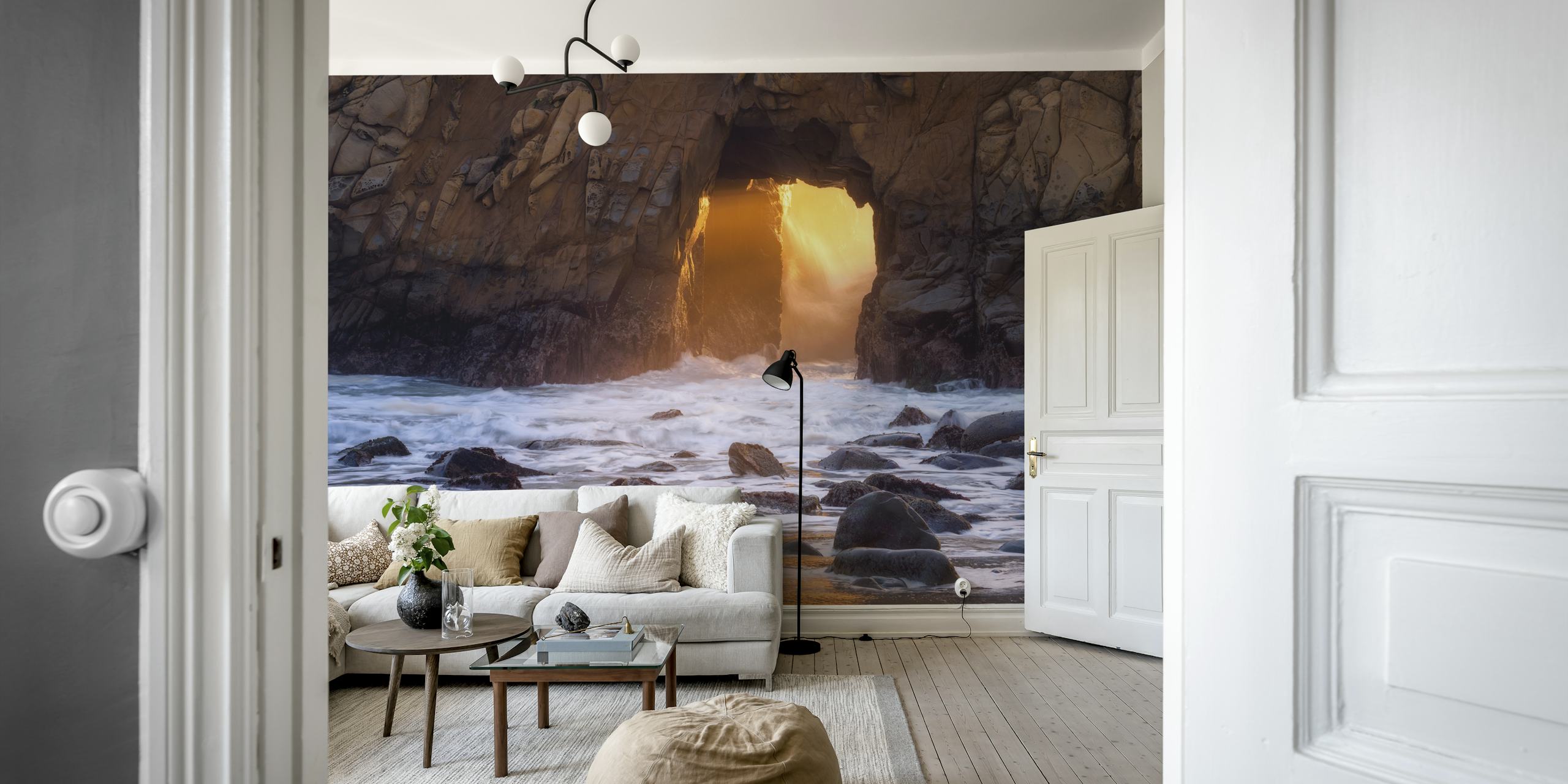 Mural de pared al atardecer con un arco de roca brillante sobre una playa