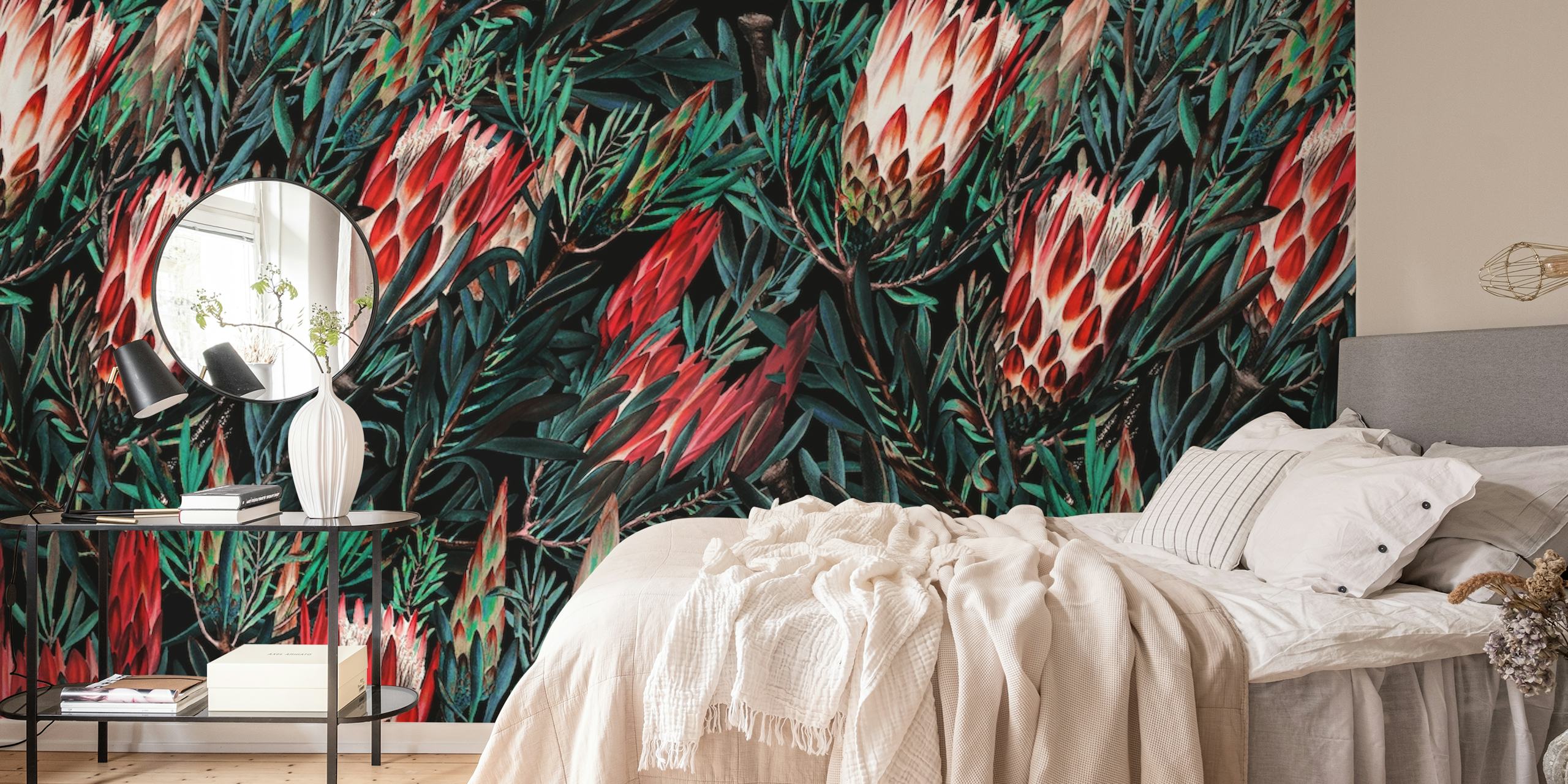 Flores de protea em tons de vermelho e rosa contra um fotomural vinílico de fundo de folhagem escura