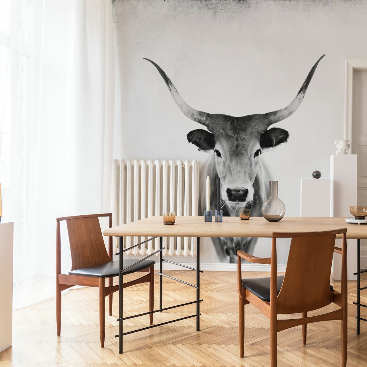 Een zwart-wit fotobehang met een serene koe met prominente hoorns tegen een gestructureerde achtergrond.