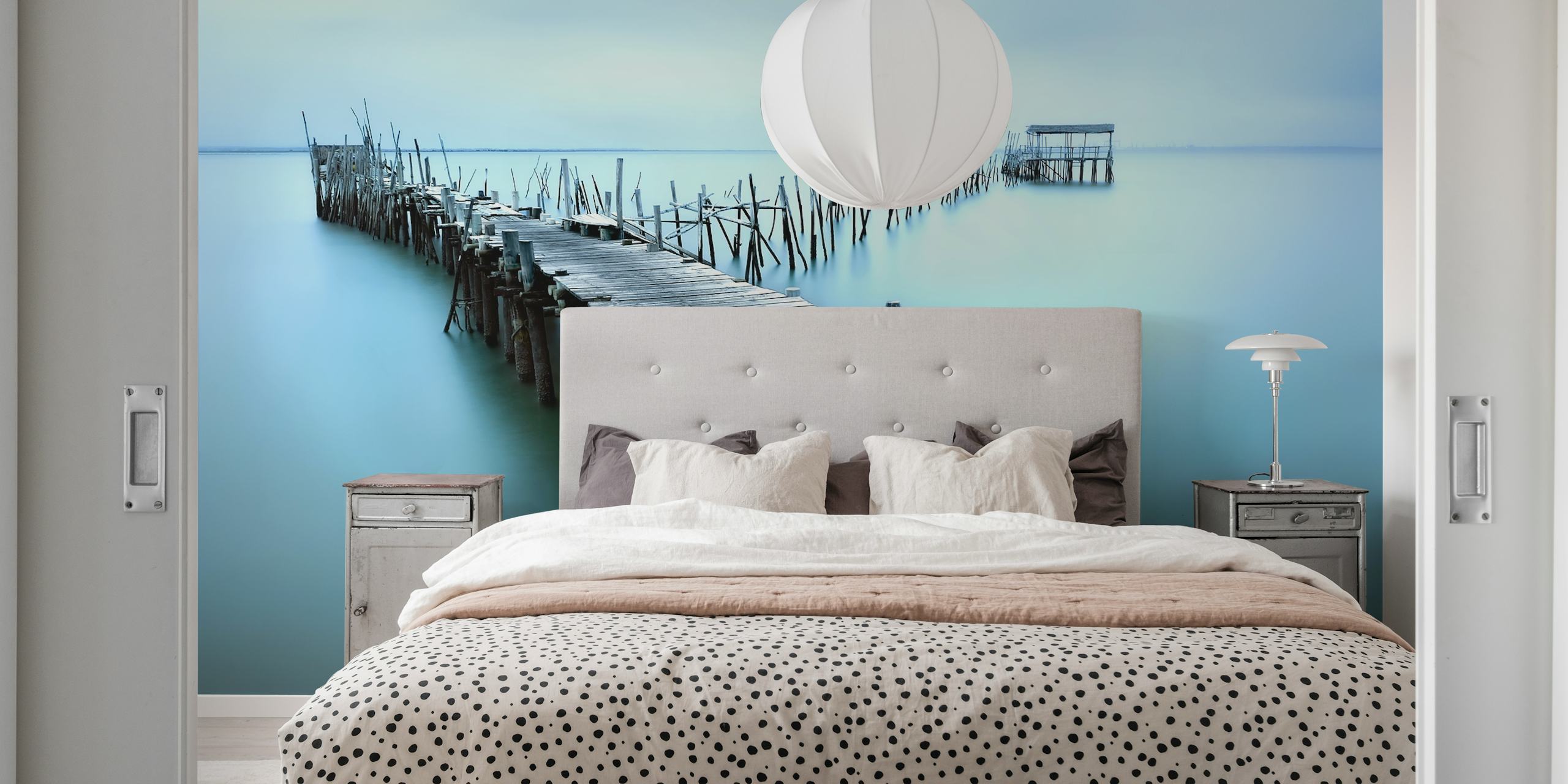 Wooden planks extending over calm blue water wallpaper