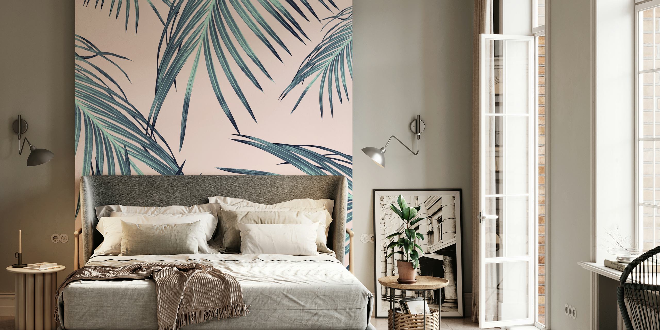 Tropical palm leaves in green and teal colors on pink wallpaper