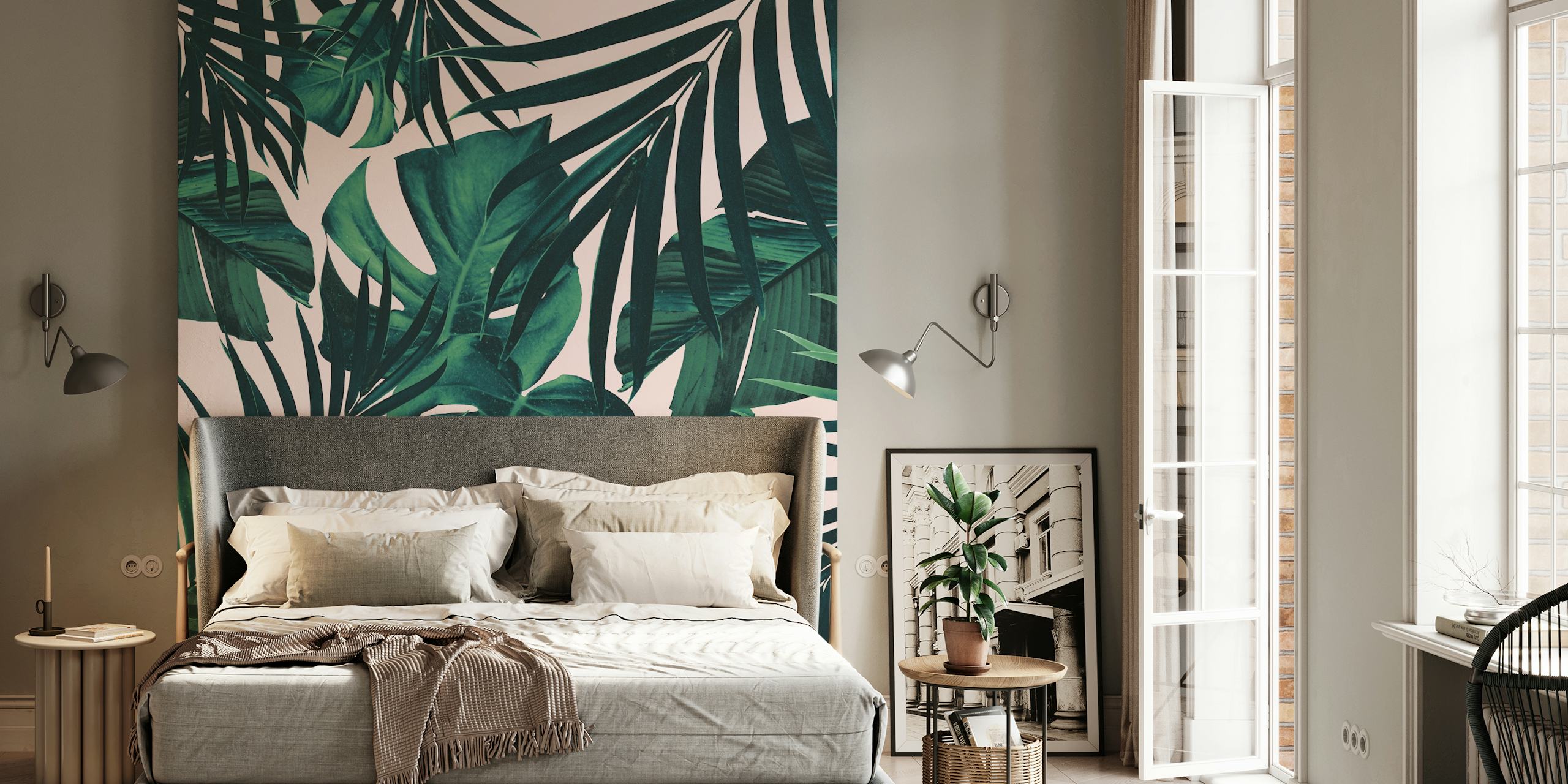 Tropical leaves in green hues on soft pink background wallpaper