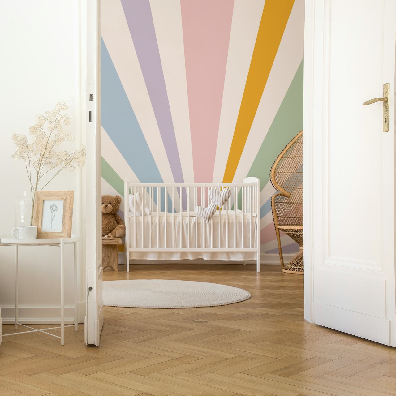 Pastel colored sunburst design with rays in light pink, lavender, green, and yellow wallpaper