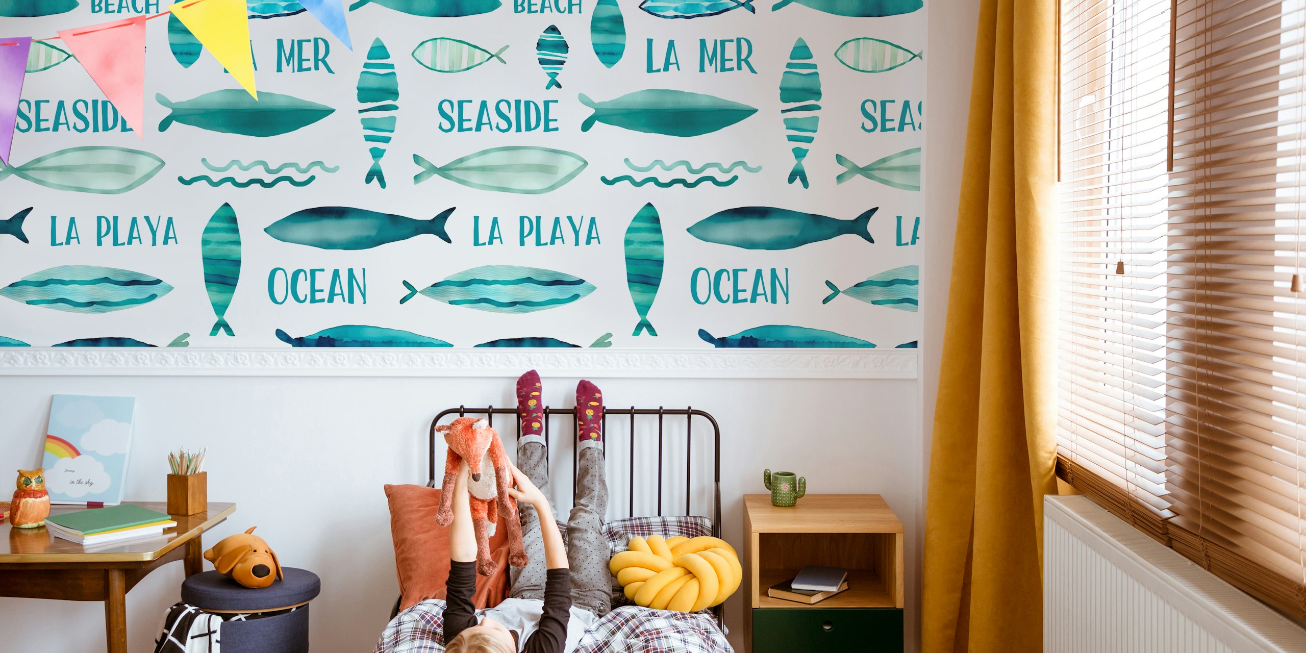 Watercolor fish pattern wall mural on a teal background with various ocean-related words