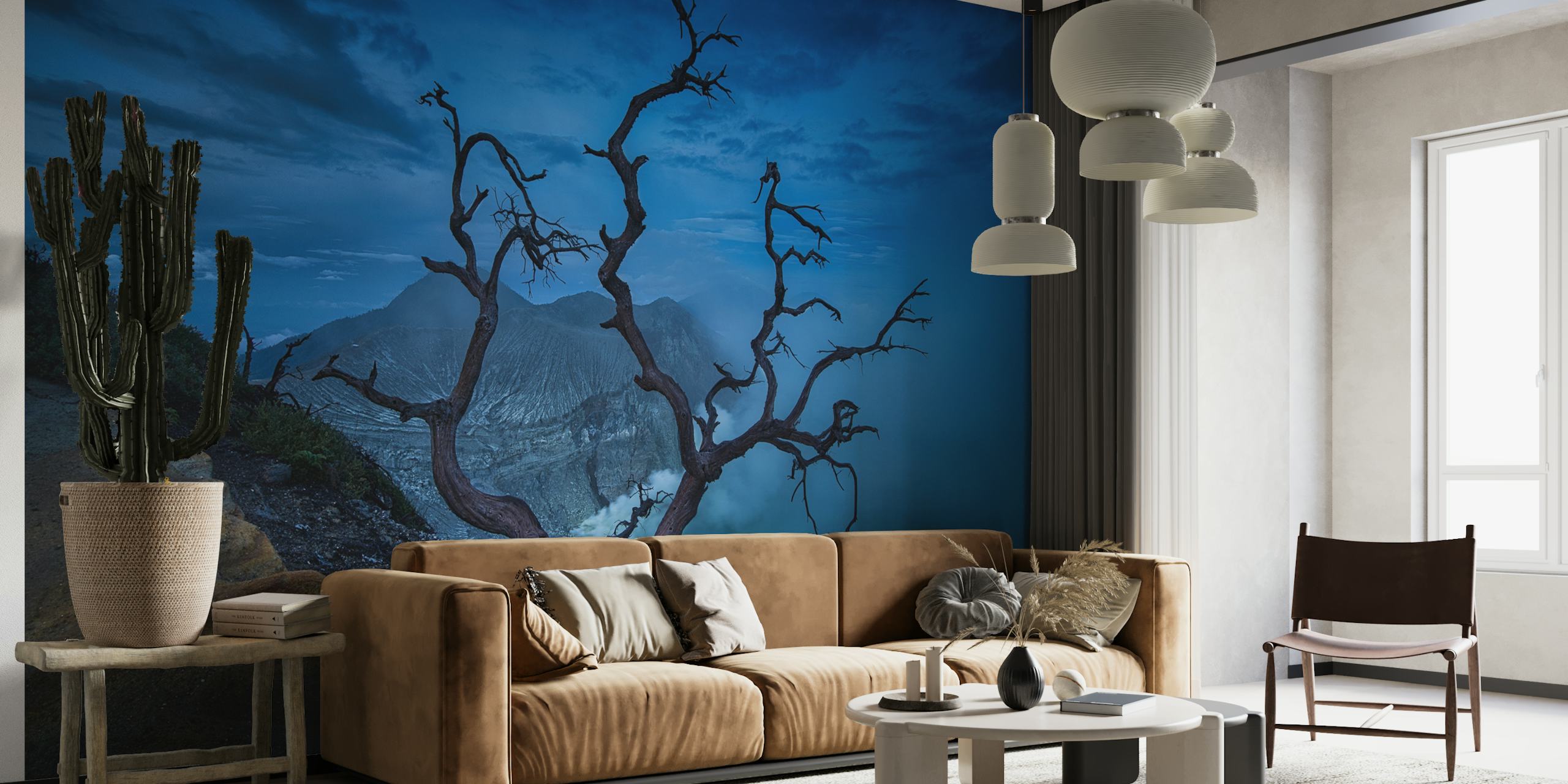 Bladlös trädsiluett mot blå gryningshimlen över Ijen-kratern