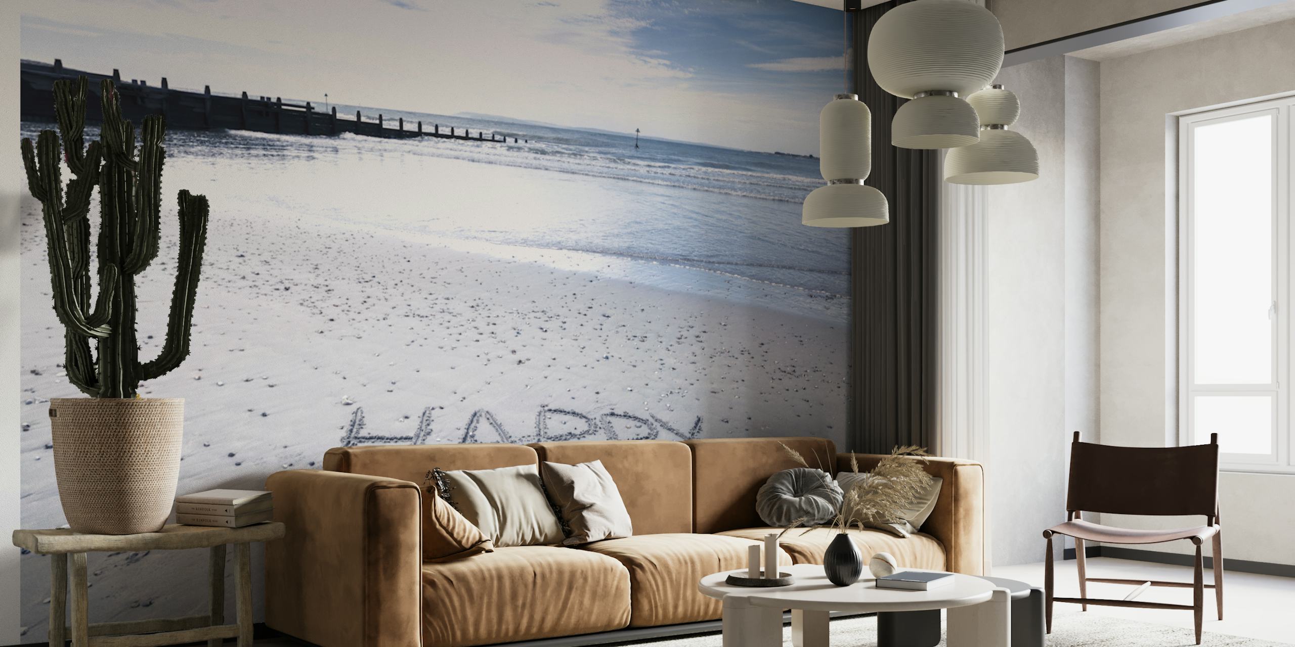 Coastal beach scene with 'HAPPY' written in sand, blue water wallpaper
