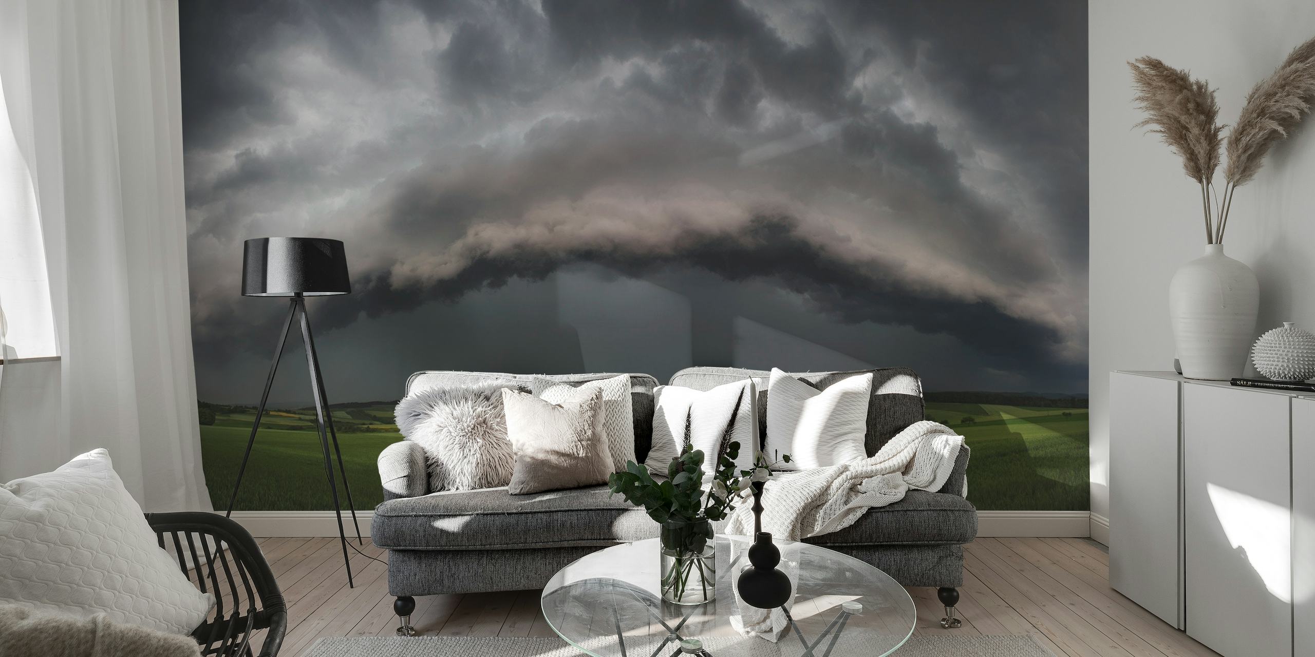 Panoramisch fotobehang van een dramatische stormwolkformatie boven een weelderig groen veld