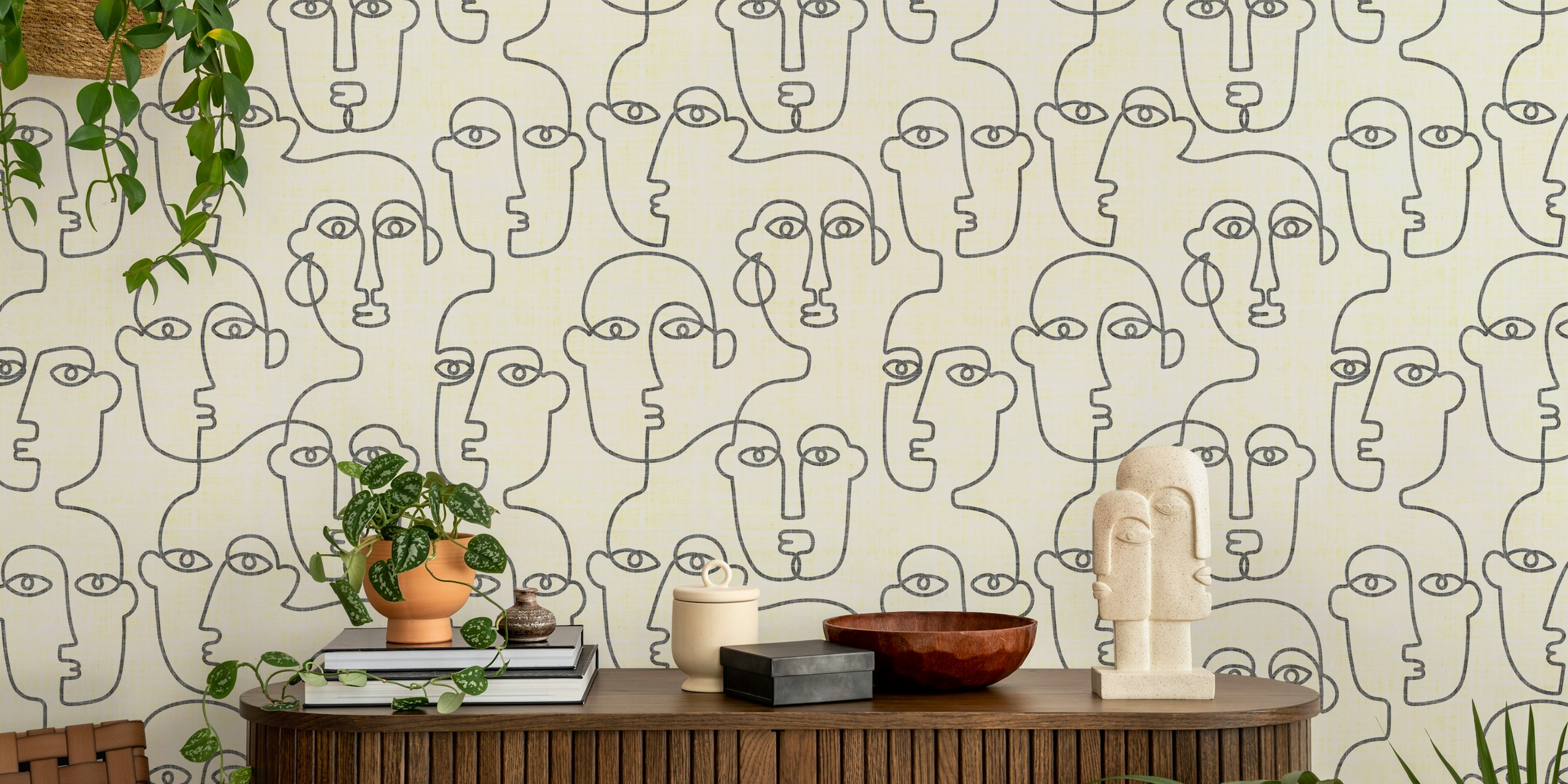 Minimalist line art faces in black on cream wallpaper