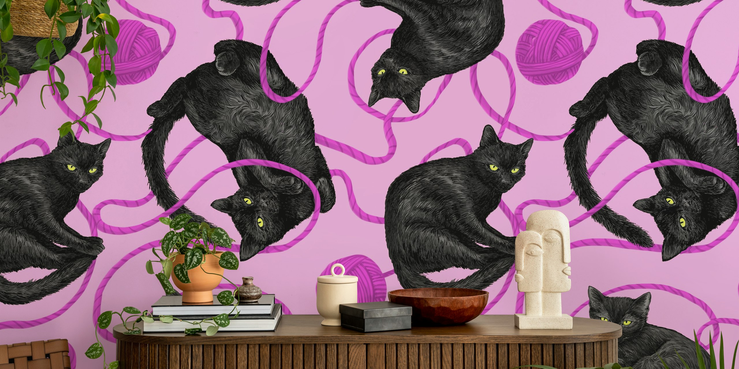 Black cats avec de la laine sur du papier peint rose