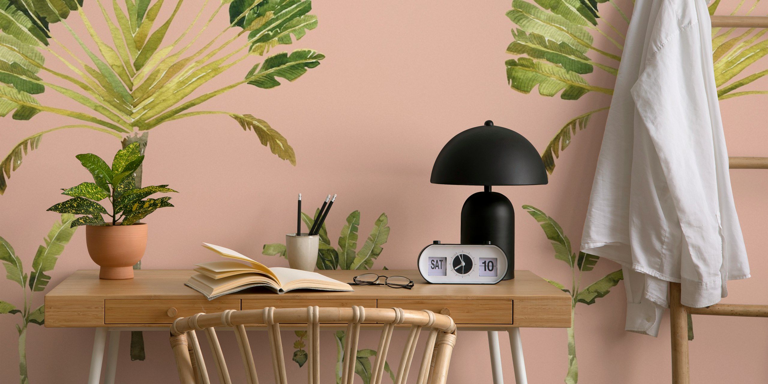 Tropical banana leaf shapes in shades of green on blush pink wallpaper