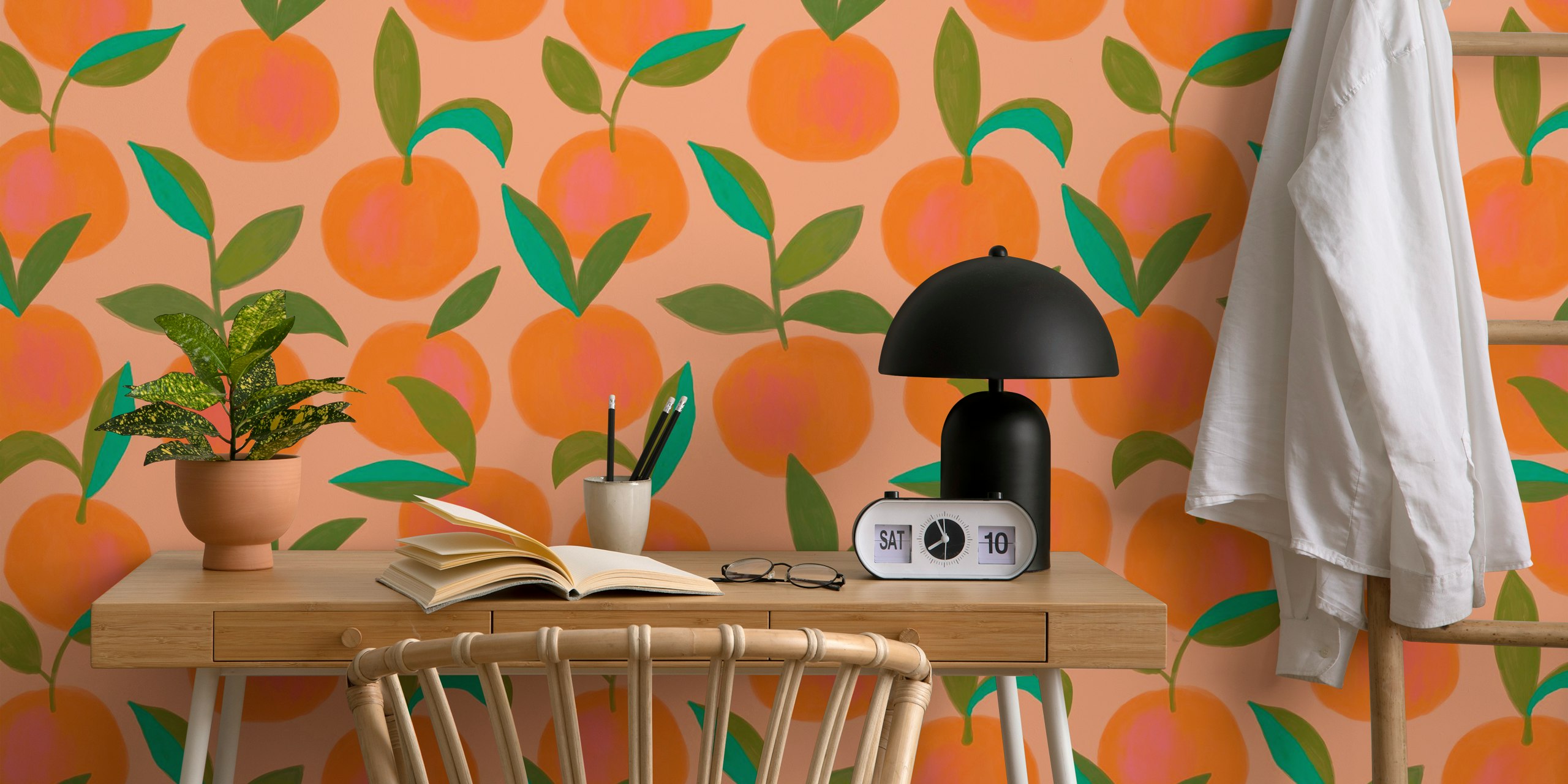 Orange citrus fruits with green leaves on soft peach background wallpaper